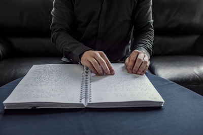 Midsection of man reading book