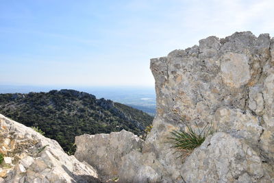 Rock formations by sea against sky