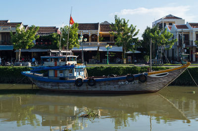 Boat moored in water against sky