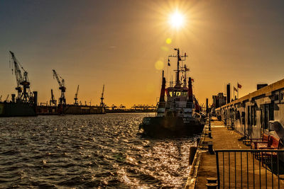 Pier at harbor against sky during sunset