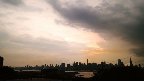 View of cityscape against cloudy sky