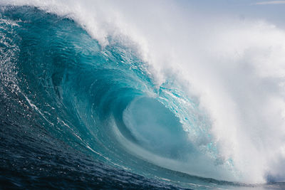 Aerial view of sea waves splashing against sky