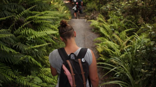 Rear view of woman standing against plants