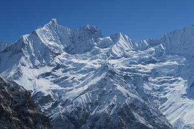 Scenic view of snow mountains against clear blue sky