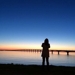 Silhouette of man standing on pier