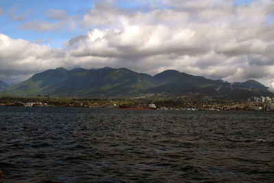 Scenic view of sea and mountains against sky