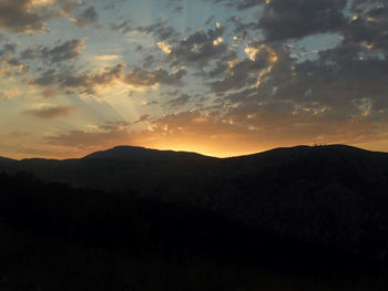 Scenic view of silhouette mountains against sky at sunset
