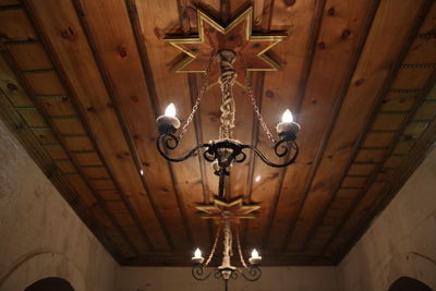 Low angle view of illuminated pendant light hanging from ceiling