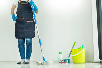 Low section worker standing against wall at home