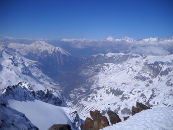 Scenic view of snowcapped mountains against blue sky