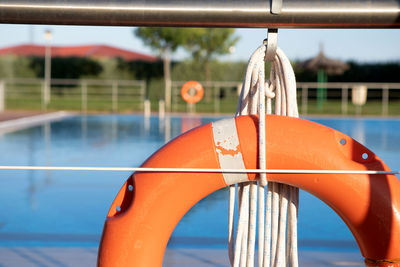 Close-up of lifebuoy hanging by swimming pool