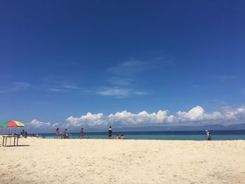 Scenic view of beach against blue sky