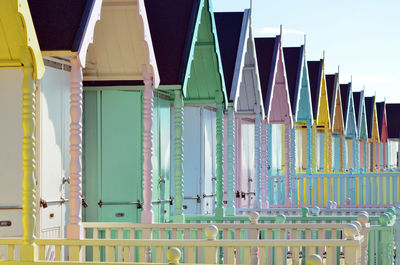 Multi colored umbrellas on beach by building against sky