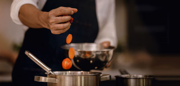 Midsection of man preparing food in kitchen at home