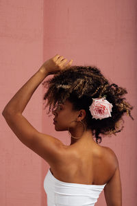 Portrait of young woman standing against wall