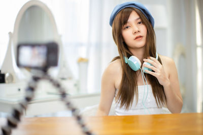 Portrait of young woman holding camera