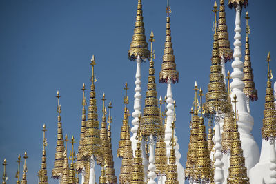 Low angle view of temple against building against clear blue sky