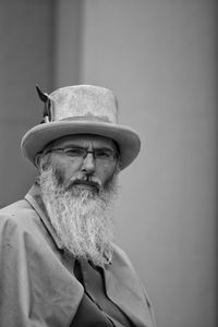 Portrait of man wearing hat against wall