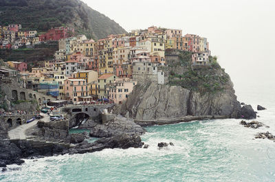 Buildings by sea against sky