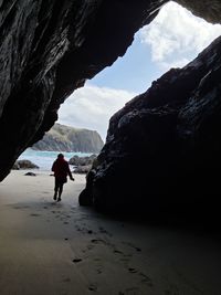 Rear view of man on rock against sky