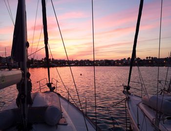 Sailboats sailing in sea during sunset