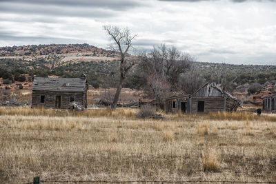 Abandoned house on field against sky