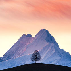 Scenic view of snowcapped mountains against sky during sunset
