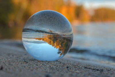 Close-up of crystal ball on beach