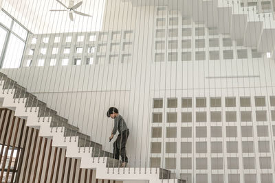 Low angle view of man walking on staircase of building