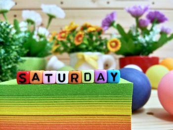 Close-up of colorful blocks with saturday text on stacked papers over table