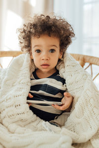 Portrait of cute boy holding mobile phone at home