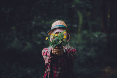 Portrait of woman standing against plants