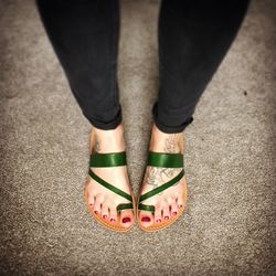 Low section of woman wearing slippers on road