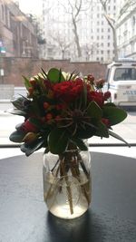 Close-up of flower vase on table in city