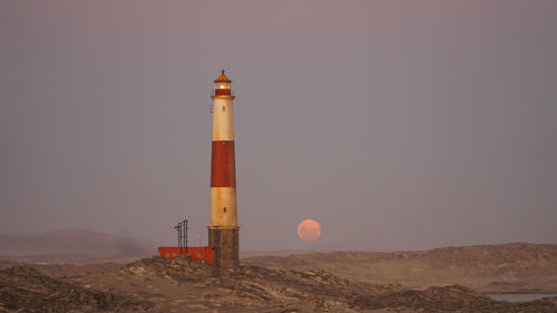 Lighthouse on land against sky