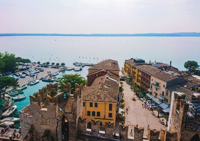 High angle view of townscape by sea against sky