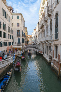 Boats moored in canal in city