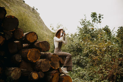 Full length of young woman sitting on rock