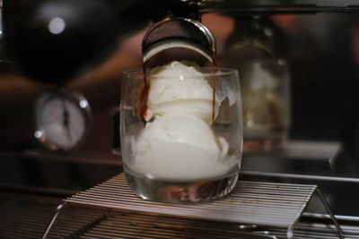 Close-up of coffee being poured cup on table