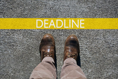 Low section of man standing on road