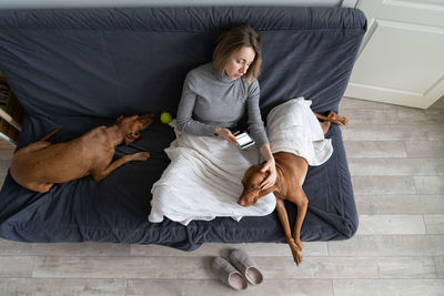 High angle view of woman with dog at home