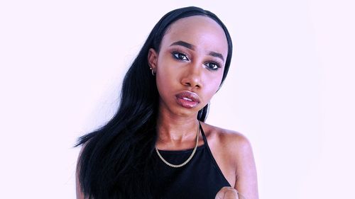 Portrait of young woman against white background