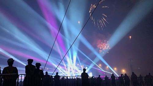 Silhouette people at music concert during night