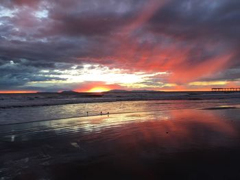 Scenic view of beach against dramatic sky