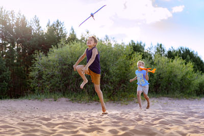 Full length of young woman running on beach