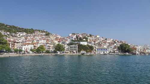 Town by sea against clear sky