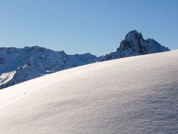 Scenic view of snowcapped mountains against clear sky