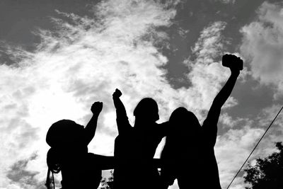 Low angle view of silhouette people against sky