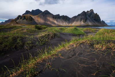 Scenic view of land and mountains against sky