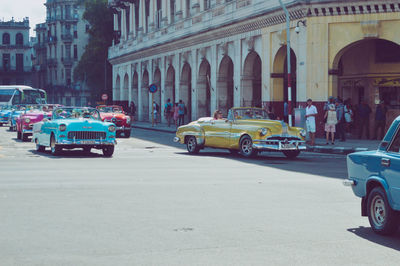 Traffic on road by buildings in city